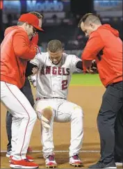  ?? Mark J. Terrill Associated Press ?? ANDRELTON SIMMONS is helped up by Angels manager Brad Ausmus, left, and team trainers.