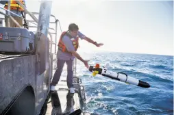  ?? Michael Short / Special to The Chronicle ?? Marine archaeolog­ist Robert Schwemmer releases a robot equipped with high-resolution cameras to scan the waters for the shipwreck.