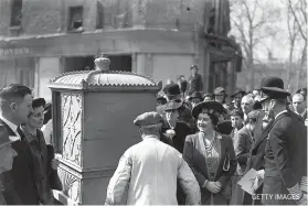  ?? GETTY IMAGES ?? On May 2 King George VI and Queen Elizabeth visited the city and are here being shown a sedan chair rescued from the ruins of a bombed building