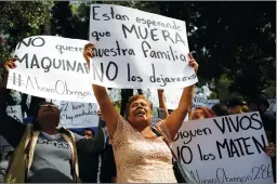  ?? Associated Press photo ?? Family members holding signs that read in Spanish “They are waiting for our family to die,” “They are still alive. Don’t kill them” and “No heavy machinery,” protest outside a quake-collapsed seven-storey building in Mexico City’s Roma Norte...