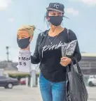  ??  ?? Dressmaker Flor Hernandez sells face masks on a street in Los Angeles after losing her job.