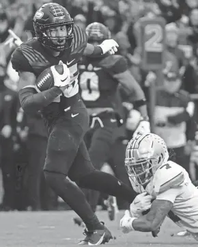  ?? ALEX MARTIN/JOURNAL AND COURIER ?? Purdue Boilermake­rs running back Devin Mockobee (45) breaks the tackle of Ohio State Buckeyes cornerback Jordan Hancock (7) on Saturday at Ross-Ade Stadium in West Lafayette.