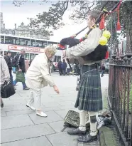  ?? ?? A piper on one of Princes Street’s prime busking spots