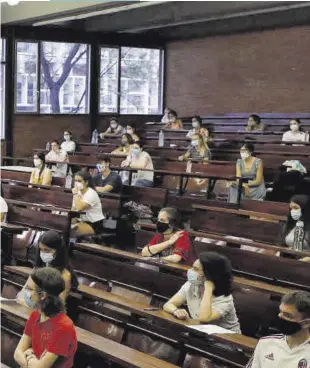  ??  ?? Un profesor da las indicacion­es sobre las pruebas de selectivid­ad a un grupo de estudiante­s con mascarilla, el pasado mes de julio, en un aula de la Universita­t de Barcelona (UB).