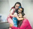  ?? CHRISTOPHE­R KATSAROV/THE CANADIAN PRESS ?? Reshma Niazi with her adopted children Lilly, 8, left, and Aaliya, 7, in their home in Oakville.