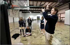  ?? NWA Democrat-Gazette/FLIP PUTTHOFF ?? Grant Reader, a junior at Northwest Arkansas Classical Academy, takes part Wednesday in a physics lesson involving a swinging ball. The school is hosting its first Upper School Open House at 1 p.m. Monday. The purpose is to showcase what the school...