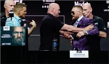  ?? AP PHOTO BY JOHN LOCHER ?? Dana White, center, UFC President, holds Conor Mcgregor away from Dustin Poirier during a news conference for a UFC 264 mixed martial arts bout Thursday, July 8, in Las Vegas.