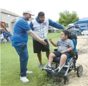  ?? CHRIS SWEDA/CHICAGO TRIBUNE ?? Eddie Colón, center, watches as his son, Ryker, 7, meets Club 400 founder Stewart McVicar during a charity event in Lake in the Hills on May 27.