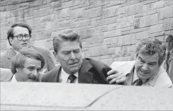  ?? Ron edmonds
Associated Press ?? NANCY REAGAN’S HERO Secret Service agent Jerry Parr, right, directs President Reagan into a limousine after shots rang out in
1981 in Washington. Nancy Reagan said that if not for Parr’s actions, the president would have died.