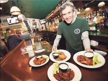 ?? Hearst Connecticu­t Media file photo ?? Kevin Canel displays a sample of buffalo, garlic parmesan, chipotle and raspberry bourbon wings at Archie Moore's Bar & Restaurant at 15 Factory Lane in Milford.