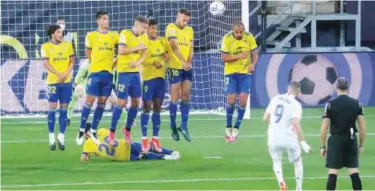  ?? Reuters ?? ↑
Real Madrid’s Karim Benzema shoots at the goal from a free kick during a Spanish League match against Cadiz on Wednesday.