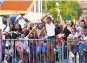  ?? GERALD HERBERT AP ?? Paradegoer­s catch prizes during “Tardy Gras,” to make up for a canceled Mardi Gras, Friday in Alabama.