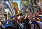  ?? JOSE CARLOS FAJARDO — BAY AREA NEWS GROUP ?? The Warriors’ Stephen Curry holds the NBA Finals MVP trophy as he greets fans during the Championsh­ip Parade on Market Street in San Francisco on June 20. The Warriors defeated the Boston Celtics to win their fourth NBA Championsh­ip in eight years.