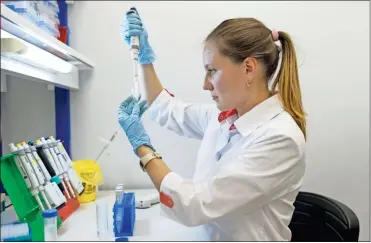  ?? AP-Alexander Zemlianich­enko Jr ?? In this handout photo taken on Thursday, Aug. 6, 2020, and provided by Russian Direct Investment Fund, an employee works with a coronaviru­s vaccine at the Nikolai Gamaleya National Center of Epidemiolo­gy and Microbiolo­gy in Moscow, Russia. Russia on Tuesday, Aug. 11 became the first country to approve a coronaviru­s vaccine for use in tens of thousands of its citizens despite internatio­nal skepticism about injections that have not completed clinical trials and were studied in only dozens of people for less than two months.