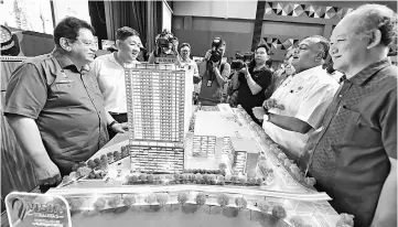  ??  ?? Tengku Adnan (left) and others taking a closer look at the Rumawip scale model after launching the ceremony and drawing of lots for Rumawip units at Residensi Vista Wirajaya and Vista Wirajaya 2. — Bernama photo