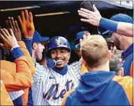  ?? Craig Ruttle / Associated Press ?? New York Mets’ Francisco Lindor is congratula­ted in the dugout after Mets’ Mark Canha drove in two runs in the third inning against the San Francisco Giants on Thursday in New York.