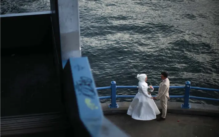  ?? ?? A young couple poses for a video and photo session at Galata bridge in Istanbul, Turkey on Thursday, May 4, 2023. Photo : AP/Francisco Seco.