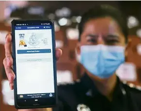  ??  ?? Keeping crime away: ASP Haryanti Che Mat showing the Semak Mule app after its launch at Royal Malaysian Police College in Cheras, Kuala Lumpur. — AZMAN GHANI/ The Star