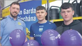  ?? (Photo: Katie Glavin) ?? Aodhan and Donnachadh Hickey on Go Purple Day, at Riordan’s SuperValu in Fermoy, meeting with Garda Aaron O’Brien.