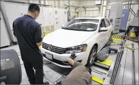  ?? DAVID MCNEW / NEW YORK TIMES ?? Technician­s test a 2013 Volkswagen Passat for diesel emissions at a lab in El Monte, Calif., on Sept. 25. The world’s largest car company admitted last month it had installed “defeat devices” in 11 million of its purported “clean” diesel vehicles.