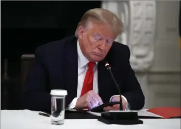  ?? ALEX BRANDON— ASSOCIATED PRESS ?? In this Thursday, June 18, 2020file photo, President Donald Trump looks at his phone during a roundtable with governors on the reopening of America’s small businesses, in the State Dining Room of the White House in Washington. Though stripped of his Twitter account for inciting rebellion, President Donald Trump does have alternativ­e options of much smaller reach.