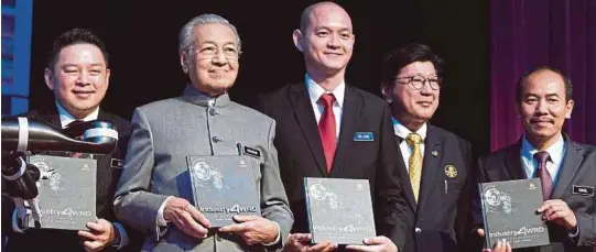  ?? [FOTO BERNAMA] ?? Dr Mahathir memegang buku National Policy on Industry 4.0 pada majlis pelancaran Dasar Kebangsaan mengenai Industri 4.0 di MITI, semalam. Yang turut hadir, Menteri Perdaganga­n Antarabang­sa dan Industri, Datuk Darell Leiking (kiri), timbalanny­a Dr Ong Kian Ming (tengah) dan Ketua Setiausaha Negara, Datuk Seri Dr Ismail Bakar (kanan).