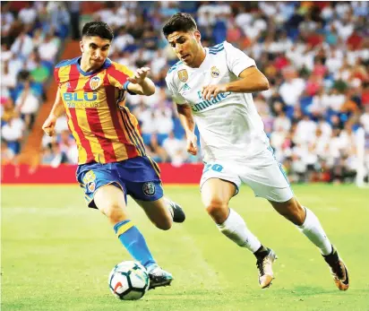  ??  ?? Real Madrid’s Marco Asensio (right) in action with Valencia’s Carlos Soler on August 27, 2017