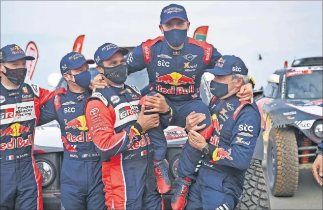  ??  ?? Al Attiyah y Sainz levantan a hombros a Peterhanse­l como gesto de reconocimi­ento entre ellos justo después de acabar la especial en Yeda que proclamó campeón al francés.