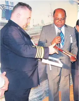  ??  ?? Captain Arkadiusz Branka (left) and Tourism Minister Ed Bartlett exchanging gifts.