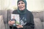  ?? MAHMOUD ILLEAN THE ASSOCIATED PRESS ?? Rana, mother of Iyad Halak, 32, holds his photo at their home in East Jerusalem's Wadi Joz.