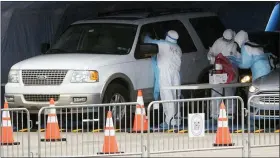  ?? MATT ROURKE - THE ASSOCIATED PRESS ?? Medical workers perform a coronaviru­s test on driver at the Temple University Ambler campus in Ambler, Pa., Wednesday, March 25.