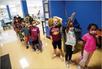  ?? PHOTOS BY STEVE SCHAEFER FOR THE AJC ?? Students line up for lunch Friday at The Walker School in Marietta, which recently mandated masks. “Some of the parents were ecstatic and some of the parents were unhappy about it,” said Christie Holman, whose job as assistant operations chief includes leading the school’s COVID-19 task force.