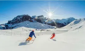  ??  ?? In Trentino Due appassiona­ti sciano in una delle piste dolomitich­e vicino a Canazei