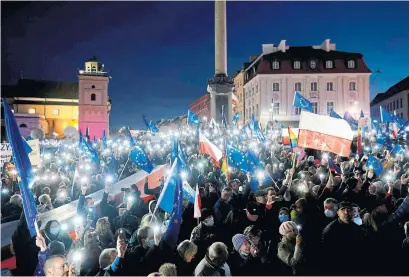  ?? WOJTEK RADWANSKI AFP VIA GETTY IMAGES ?? Protesters shine their phones and wave European Union flags during a pro-EU rally in Warsaw Sunday. Poland’s top court issued a landmark ruling last week against the primacy of European Union law, sparking fears the country may be forced to leave the bloc.