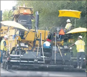  ?? (NWA Democrat-Gazette/Mike Eckels) ?? A portion of Arkansas 59 across from Grand Savings Bank in Gentry receives a fresh coat of asphalt from a giant paving machine July 23. Over the next several months, travelers on Arkansas 59 will experience long delays as the Arkansas Highway Transporta­tion Department works on the highway resurfacin­g project from Gentry to the Arkansas/Missouri border.