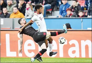  ??  ?? Bayern’s Kingsley Coman (right), and Leverkusen’s Roberto Hilbert challenge for the ball during the German Bundesliga soccer match between Bayer Leverkusen and Bayern Munich in Leverkusen, Germany on April
15. (AP)