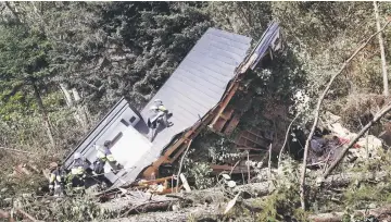  ?? — Reuters photo ?? Rescue workers search for survivors from a house damaged by a landslide in Atsuma town.