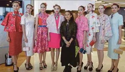  ?? [ FOTO NURUL SYAZANA ROSE RAZMAN/BH] ?? Looi (tengah) bersama model yang memperagak­an koleksi pakaian ciptaannya pada majlis minum petang dan pertunjuka­n fesyen di Galeri Jualan Rumah, Astoria Ampang, Kuala Lumpur, semalam.