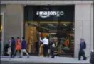  ??  ?? People walk past and into an Amazon Go store in San Francisco. Get ready to say good riddance to the checkout line. A year after Amazon opened its first cashierles­s store, startups and retailers are racing to get similar technology in other stores throughout the world, letting shoppers buy groceries without waiting in line.