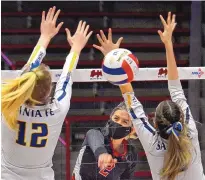  ?? JIM THOMPSON/JOURNAL ?? Centennial’s Alexie Stiles (2) drives home a kill between the block attempts of Santa Fe’s Jorja Chambers (12) and Sydney Pino-Pacheco. The Hawks swept their way to the 5A title.