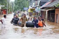  ??  ?? Rescuers evacuate people from a flooded area to a safer place in Aluva on Saturday.