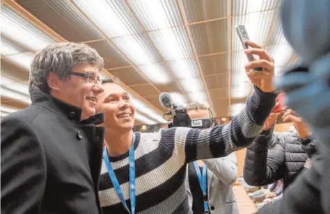  ?? AFP ?? Puigdemont, fotografia­do en un «selfie» que realiza uno de los asistentes a su acto del domingo en Ginebra