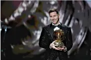  ?? AP Photo/Christophe Ena ?? ■ PSG player Lionel Messi reacts after winning the 2021 Ballon d’Or trophy during the 65th Ballon d’Or ceremony at Theatre du Chatelet on Monday in Paris.