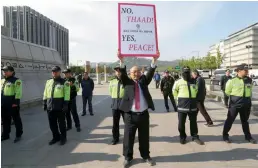  ?? — AP ?? A South Korean protester holds up a placard opposing a plan to deploy the advanced US missile defence system called Terminal High-Altitude Area Defence, or Thaad, near the US Embassy in Seoul on Thursday.