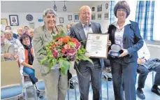  ?? FOTO: JOSEF ASSFALG ?? Christian Stetter ist von Bürgermeis­terin Monika Brobeil (rechts) die Bürgermeda­ille der Gemeinde Attenweile­r verliehen worden. Mit dabei seine Ehefrau Johanna Stetter.