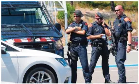  ??  ?? Officers control vehicles as they cross the Spanish-French border between La-Jonquera, Spain, and Le-Perthus, France