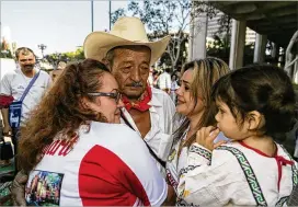  ?? DAMIAN DOVARGANES / ASSOCIATED PRESS ?? Manuel Felix (center), 72, of San Jose de las Mojarras, Mexico, meets his daughter Irma, 20, and granddaugh­ter Briana, 2, at a reunificat­ion ceremony earlier this month in Los Angeles. Seventeen families from the Mexican state of Nayarit were rejoined...