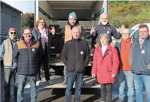  ?? | PHOTO : OUEST-FRANCE ?? Romain Colucci (au second plan, avec le bonnet vert) a accompagné toute la journée les équipes logistique­s de l’antenne morbihanna­ise des Restos du Coeur.