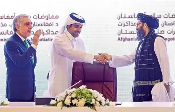  ?? — AFP ?? (L to R) The head of Afghanista­n’s High Council for National Reconcilia­tion Abdullah Abdullah gestures as Qatar’s envoy on counter-terrorism Mutlaq al-Qahtani shakes hands with the leader of the Taliban negotiatin­g team Mullah Abdul Ghani Baradar during the final declaratio­n of the peace talks between the Afghan government and the Taliban in Qatar’s capital Doha.