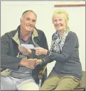  ??  ?? HELPING HANDS: Henry van Oosten, chairman of the board of Madeira Home, receives a cheque for more than R14 000 from Peggy Greeff, a committee member of the Love of Art organisati­on. The money was raised at this year’s charity art exhibition